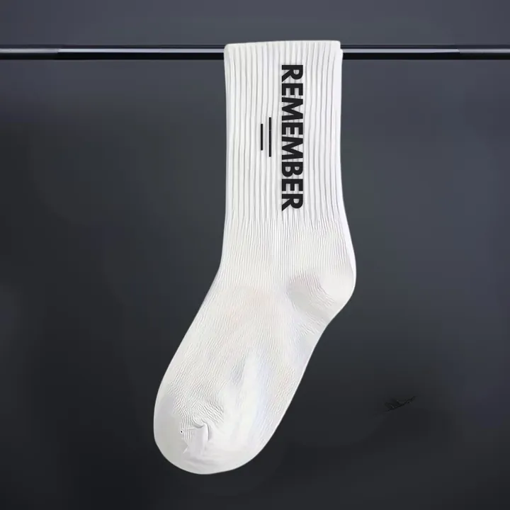 White sock with the word Remember down the side.